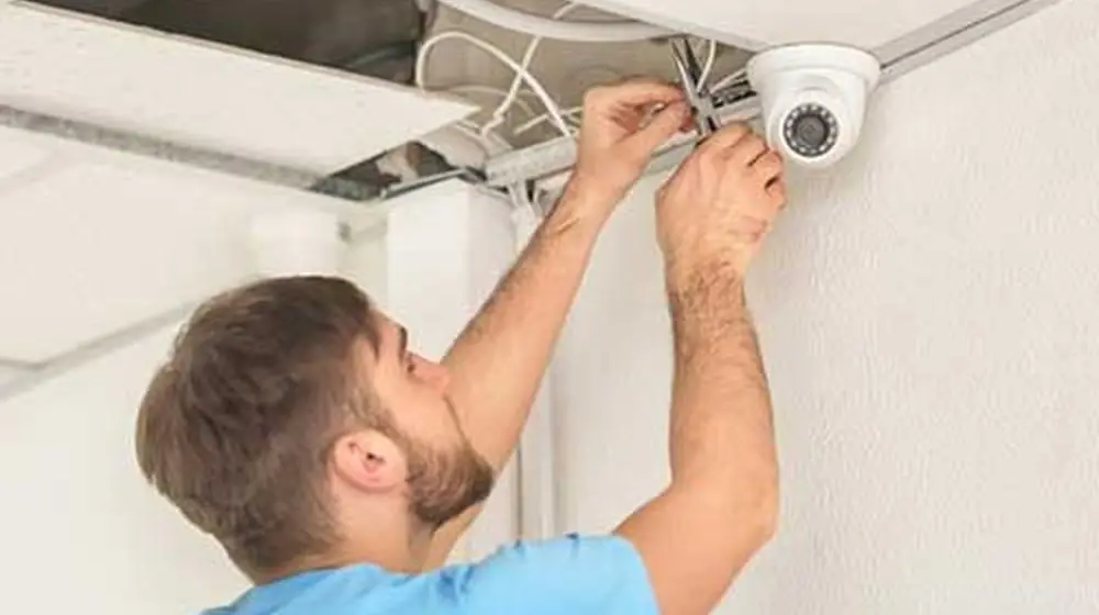Tecnico che installa una telecamera a cupola sul soffitto